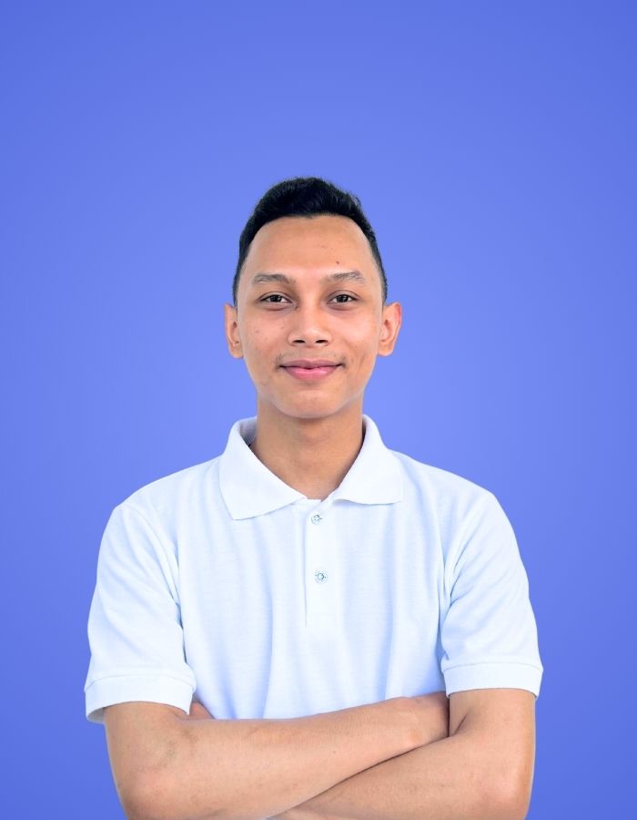 Male SitesGuru team member wearing a white shirt with arms crossed against a blue background.