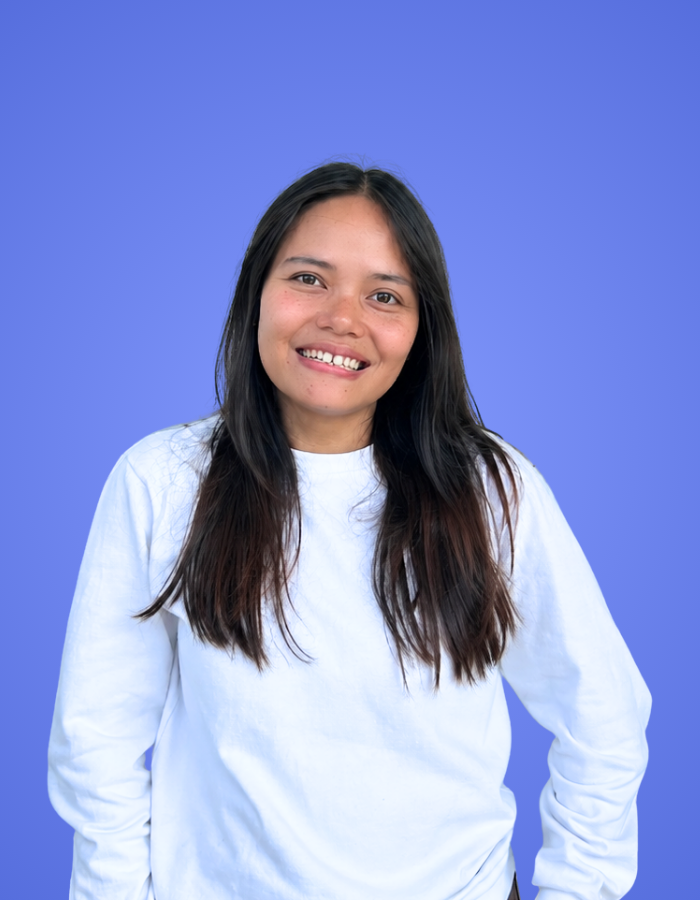 Woman from the SitesGuru our team wearing a white shirt against a blue background.