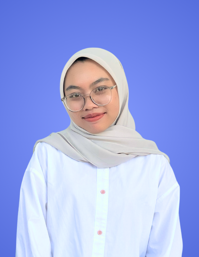 Female SitesGuru team member wearing a light-colored hijab and white shirt against a blue background.