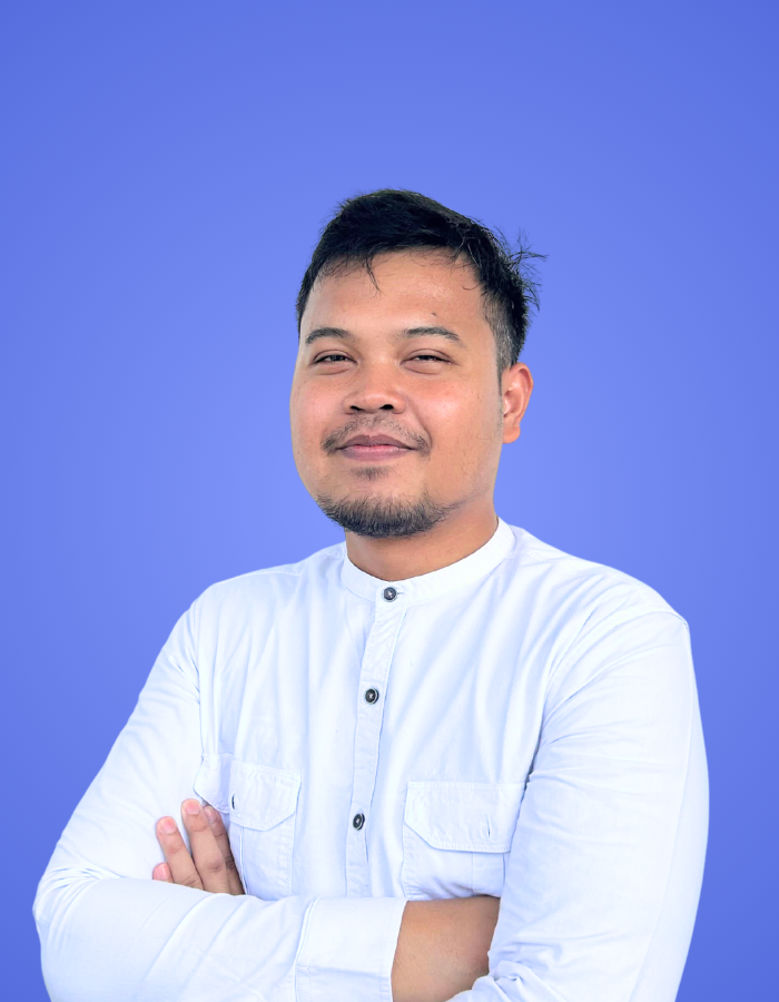 Male SitesGuru team member wearing a white shirt with arms crossed against a blue background.