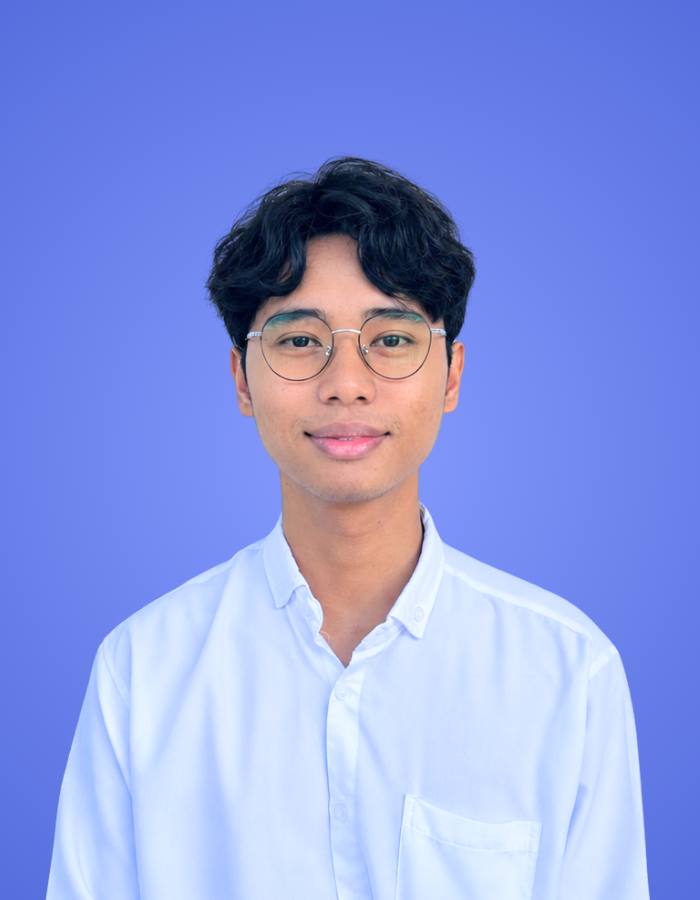 Team member profile photo of a young man with glasses on a purple background for Our Team page.
