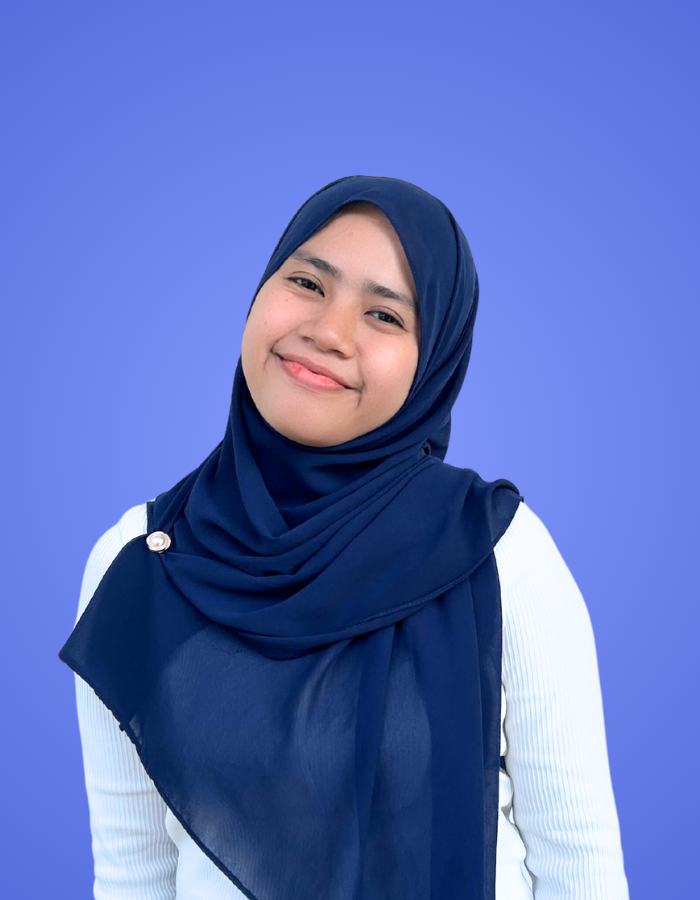 Female SitesGuru team member wearing a navy hijab and white shirt against a blue background.